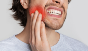 persona notando dolor al morder un alimento