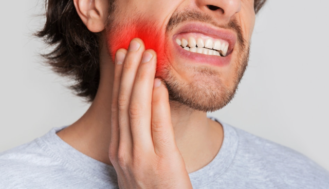 persona notando dolor al morder un alimento